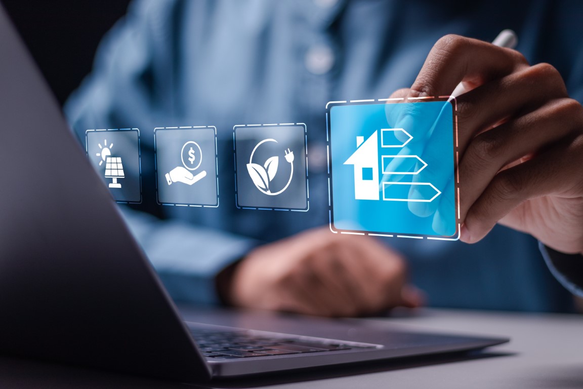 Energy efficiency concept. Businessman use laptop with virtual screen of energy efficiency rating for energy efficient house building rate label audit.